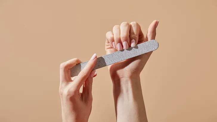 De ongelakte nagel met een glittervolle vijl