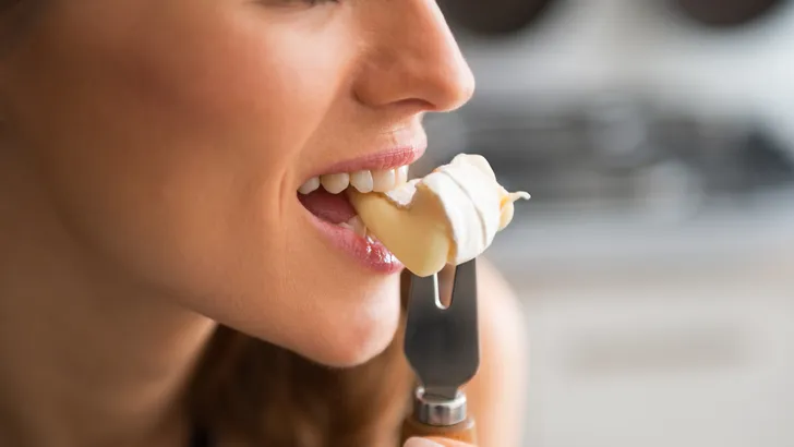 Vrouw pakt na het avondeten een stukje kaas in plaats van een zoet dessert aan tafel.
