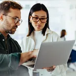 Design professionals using a laptop together in an office