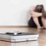 Weight loss fail concept. Scale and depressed, frustrated and sa