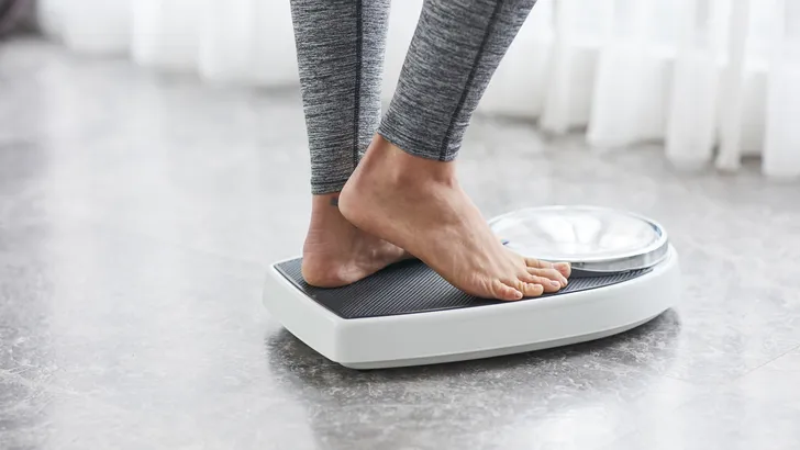 Young healthy girl on home scales