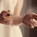 Vrouw test parfum op haar polsen.