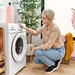 Vrouw doet was in de wasmachine.