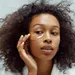 Foto van vrouw met skincare bij spiegel. – Skincare fout die voor wallen zorgt