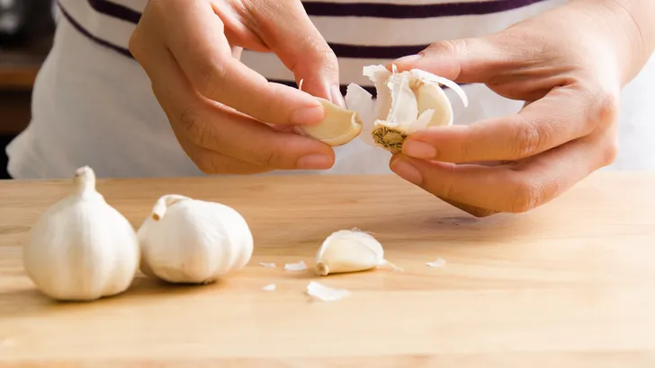 Woman peeling garlic by hand