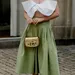 Vrouw in stijlvolle outfit met zwierige plooirok.