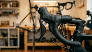 Een close-up van een linker shifter op een racefiets, waarmee je de voorderailleur kunt trimmen.