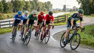 Mannelijke wielrenner met helm komt uit het zadel om op te trekken na een bocht tijdens een groepsrit.
