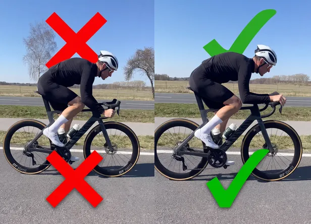 Een wielrenner demonstreert de aerodynamische fietshouding met zijn handen smal op de remgrepen, ook wel de 'hoods-positie' genoemd, om de luchtweerstand op de racefiets te verminderen.