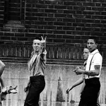 Skinheads walk by giving the Two Fingered Salute