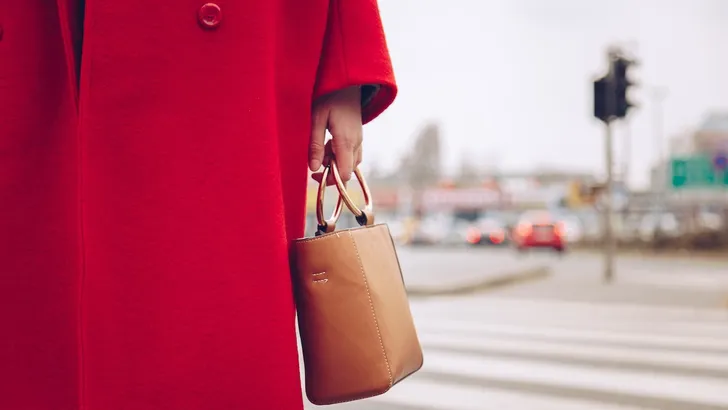 De Weekendtips van Beau Monde – Foto van vrouw met handtas en rode wollen jas.