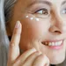 Close-up van vrouw die oogcrème smeert