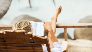 Young woman reading a book while relaxing on tropical island