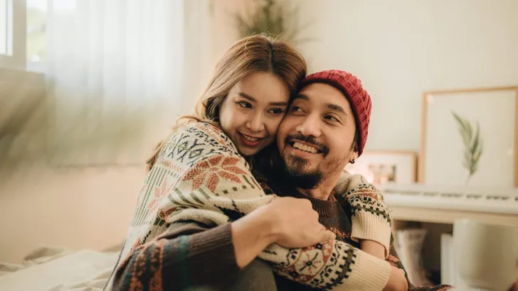 Happy young couple relaxing talking laughing drinking coffee tea