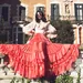 vrouw met grote rode rok zit op muurtje - looks