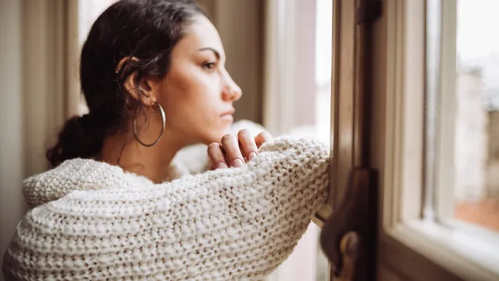pensive woman in front of the window