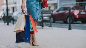 Young woman is standing with bags outdoors