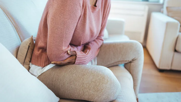 Cropped shot of an attractive young woman lying down on her bed and suffering from period pains at home.