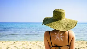 Foto van vrouw met zonnebrandcrème op strand. – Perfecte zonbescherming bij jouw huid kiezen