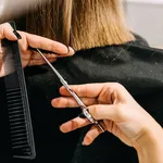 Process of hair cutting at a beauty salon, using scissors. Hair