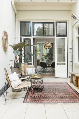 De openslaande deuren maken de tuin een verlengde van onze woonkamer. Het Perzische tapijt betrekt buiten mooi bij binnen.