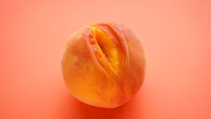 Fresh peach on a orange background. Sex concept