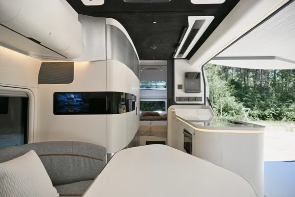 Vanuit het woongedeelte kijk je langs de keuken naar de afzonderlijke slaapkamer achter in de caravan.