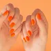 Handen met oranje nagellak voor oranje achtergrond