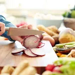 Midsection image of woman cutting onion in kitchen