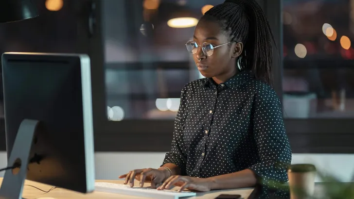 Pretty happy entrepreneur woman working with laptop sitting in the office.