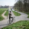 Een wielrenner van achteren gezien op een kruispunt, met een keuze tussen een stedelijke en een landelijke route.