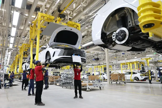 Arbeiders werken aan een witte BYD aan de lopende band in een autofabriek in Brazilië. Beeld: NL Beeld / Abaca Press.