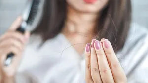 woman hand holding hair fall from hairbrush