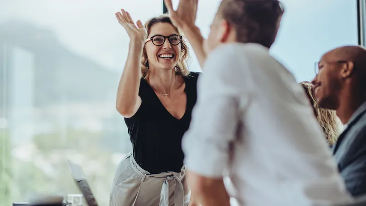 Businesswoman giving a high five to a colleague in meeting