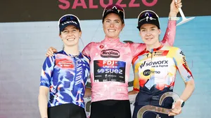 Demi Vollering in de roze trui als het stralende middelpunt op het Giro-podium.