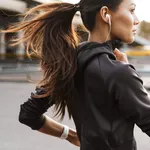 Strong fitness woman running outdoors by street.