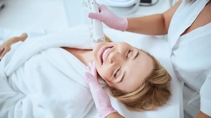 Young female client enjoying the microneedling procedure