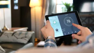 Man is Adjusting a  temperature using a tablet with smart home a