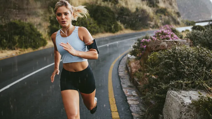 Female athlete running outdoors on highway