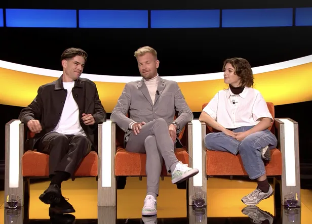 Wout van Aert zit als kandidaat in De slimste mens ter wereld naast de andere deelnemers in de studio.