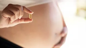 Happy pregnant woman showing medicine