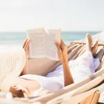 Woman reading book in hammock