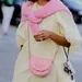 Vrouw in botergele jurk met roze accenten.