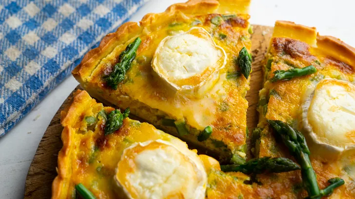 French style quiche with green asparagus, eggs, and slices of goat cheese.