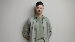Simon Keizer vertelt over romantiek. – Foto van Simon Keizer tegen grijsgroene achtergrond.