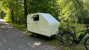 Deze caravan voor achter je e-bike heeft slaapplek voor twee personen en een toilet
