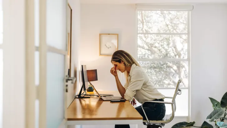 Exhausted businesswoman having a headache in her office