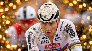 Close-up van Mathieu van der Poel in modderige cross, met warme kerstlichtjes (bokeh) op de achtergrond en zachte vallende sneeuw voor een feestelijke kerstsfeer.