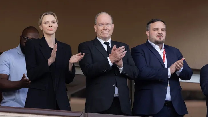 Foto van prinses Charlene, prins Albert en Gareth Wittstock applaudisserend bij het Sainte Dévote rugbytoernooi.
