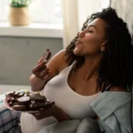 Happy pregnant woman with a plate full of sweets.